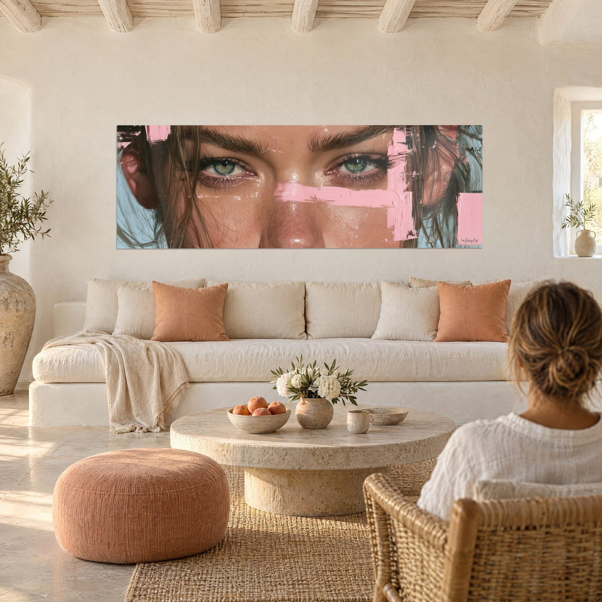 Cuadro con mirada verde enmarcada por cejas castañas, banda rosa y fondo azul, sobre un sofá en un salón luminoso