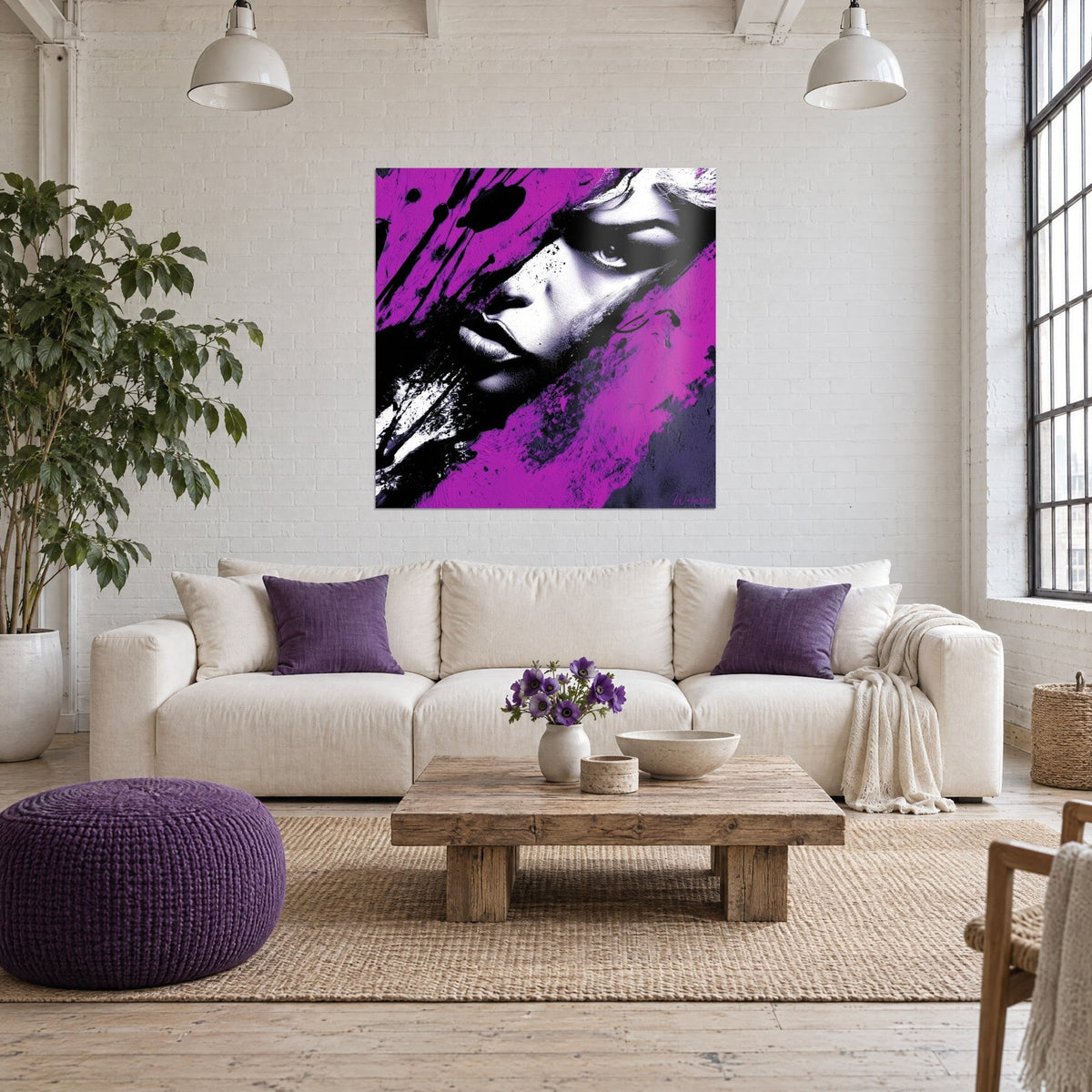 Gemälde Frauengesicht mit intensivem Blick, fuchsia und schwarz gespritzt, über einem Sofa in einem hellen Wohnzimmer