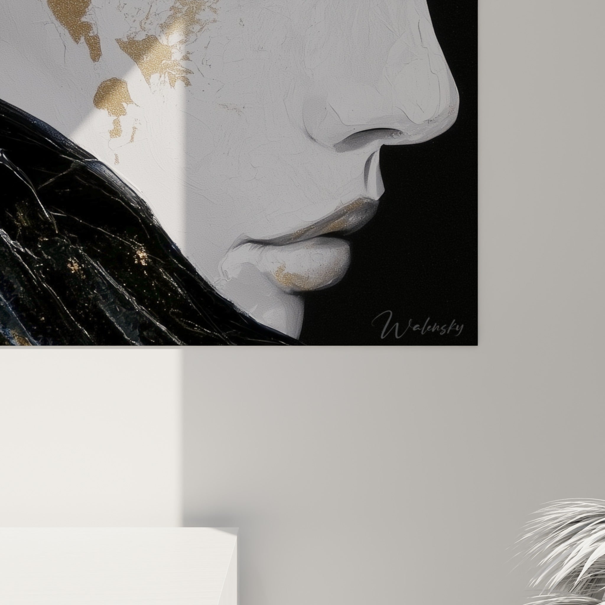 Empâtements dorés et coulures noires sur la toile, grain visible du visage abstrait accroché