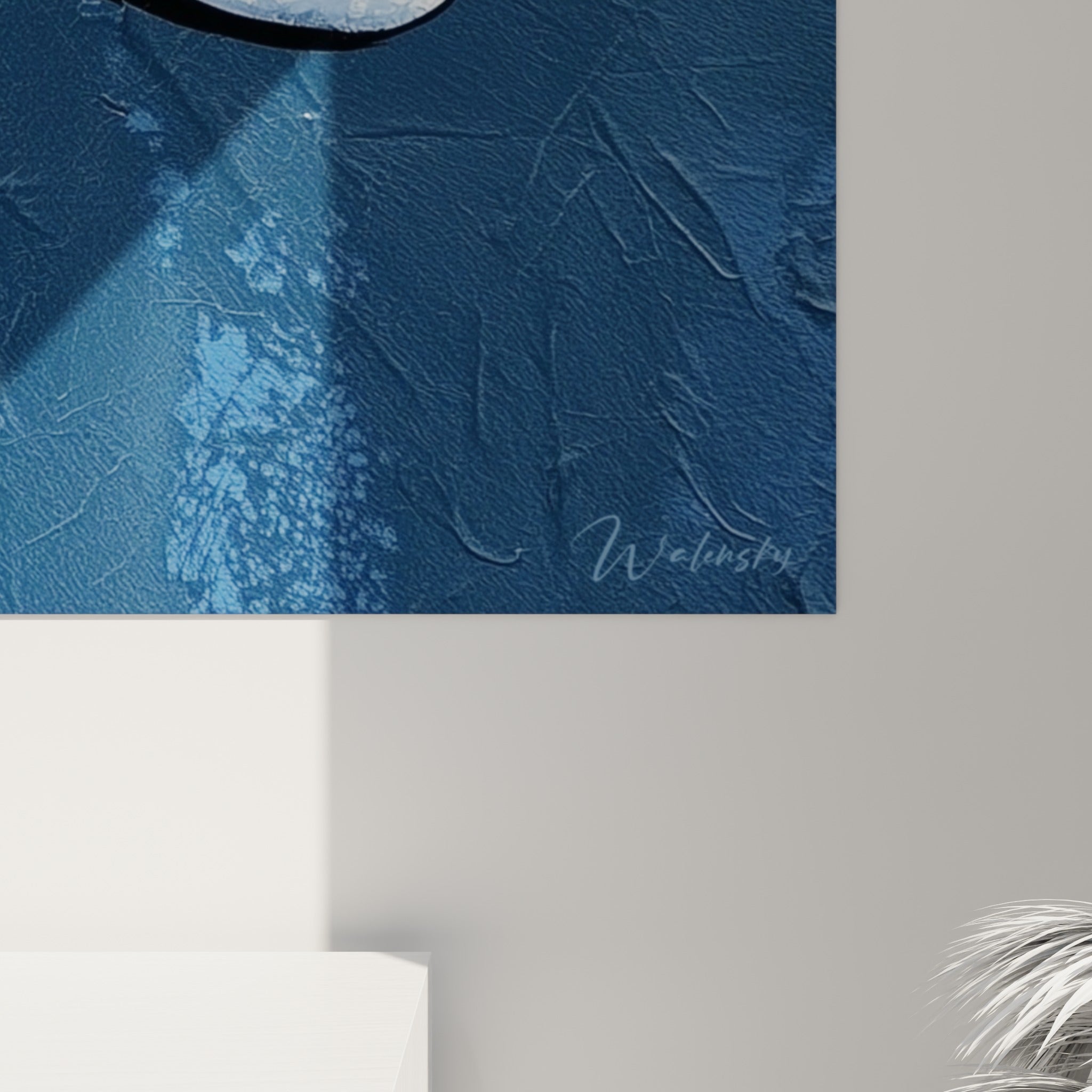 Matière éclaboussée bleu marine et blanche, grain de peinture visible sur ce tableau visage abstrait accroché au mur