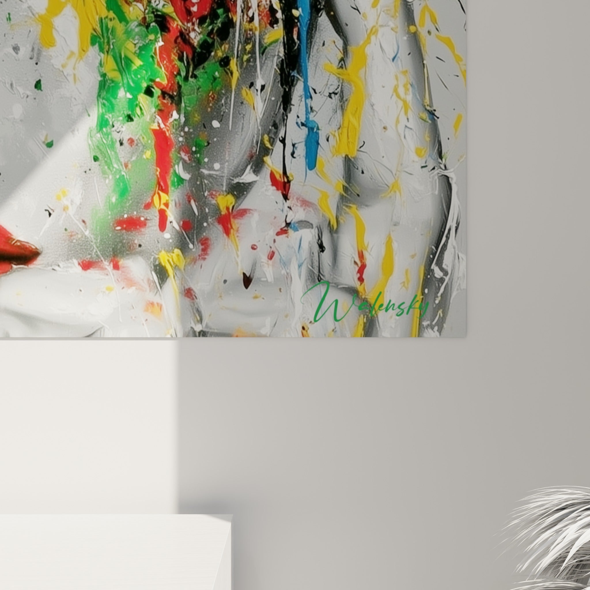 Empâtements de peinture rouge et jaune se mêlant sur le grain du visage abstrait accroché au mur