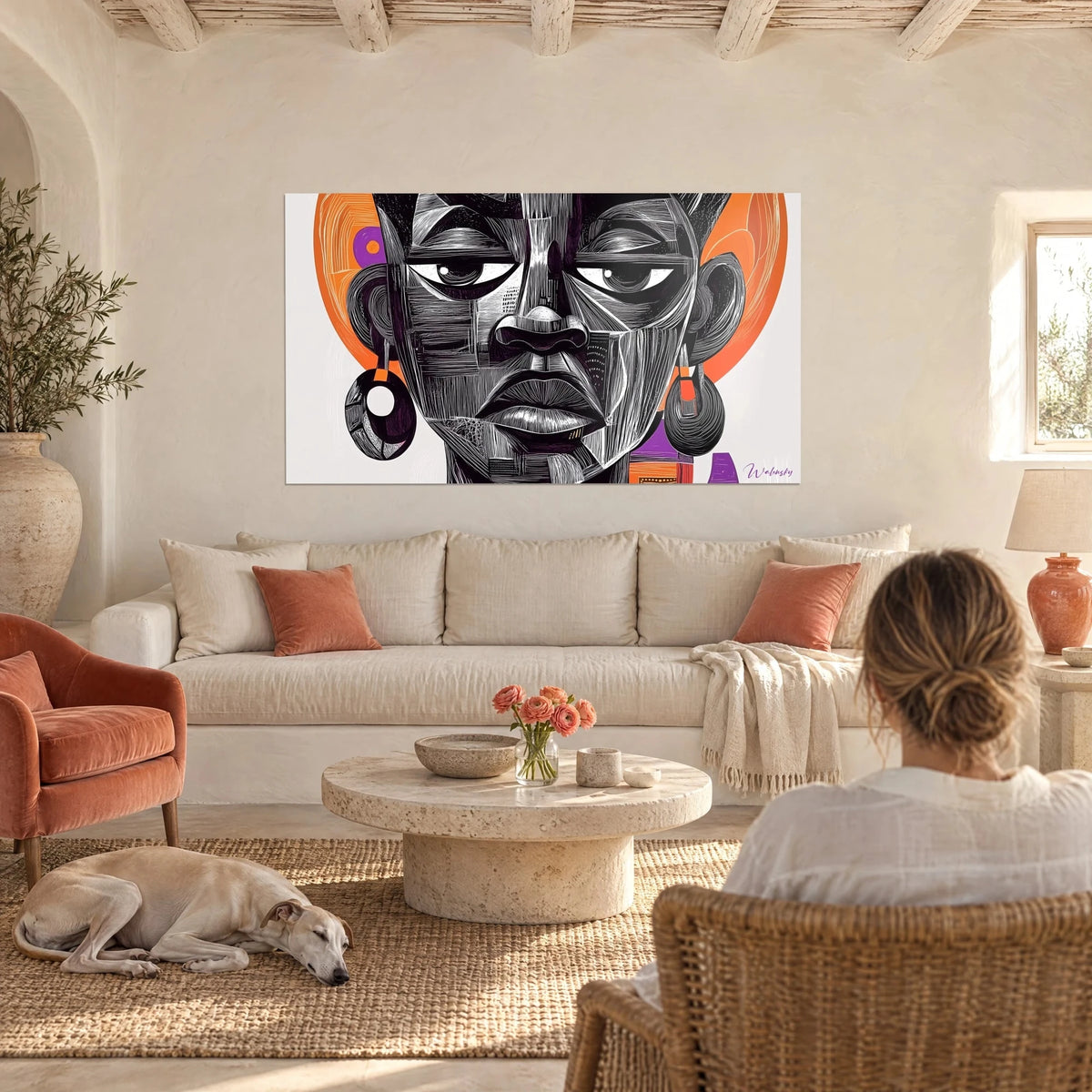 Tableau visage africain gravé de hachures noires sur disque orange, au-dessus d'un canapé dans un salon lumineux