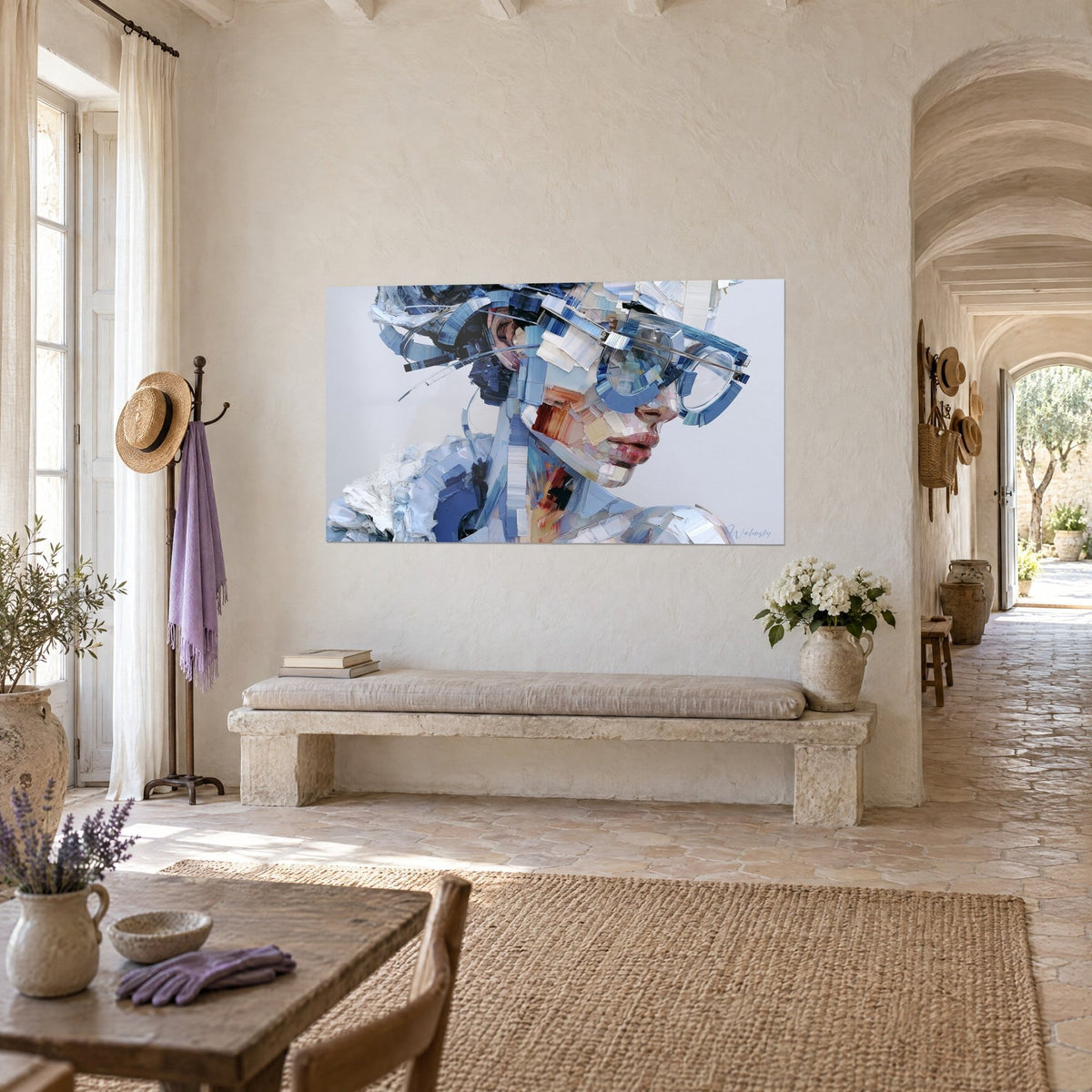 Tableau visage sculpté en éclats de peinture, monture ronde bleu ardoise et lèvres rosées, accroché près d'un banc de pierre dans un mas