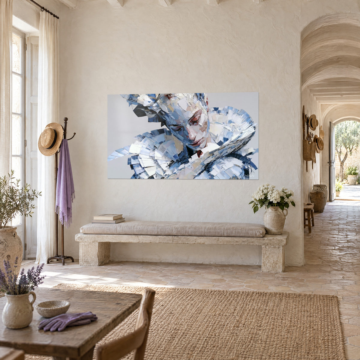 Wall art female face fragmented into strips of cobalt blue and white paper, rosy cheek, on a stone wall of a Provençal farmhouse