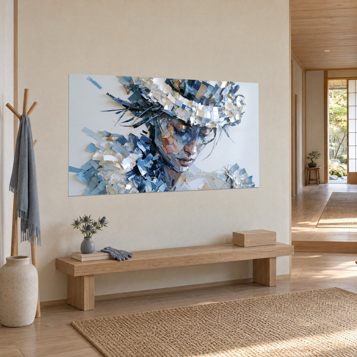 Tableau portrait en collage de papiers déchirés, joue rosée et chapeau bleu et blanc, mur beige, banc en bois clair japandi