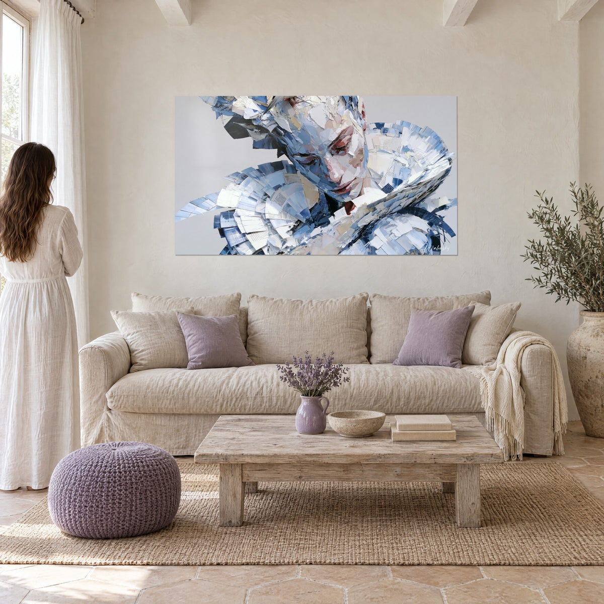 Wall art portrait of a woman with closed eyelids, shards of blue and ivory paper, in a living room, above a sofa in a bright lounge
