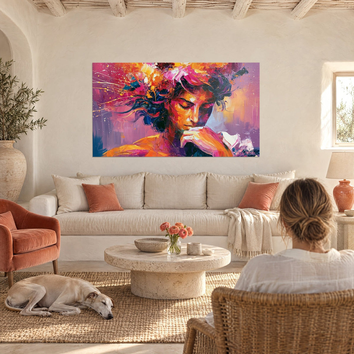Wall art female portrait with closed eyelids, indigo hair and orange and pink flowers, sleeping greyhound, above a sofa in a bright living room