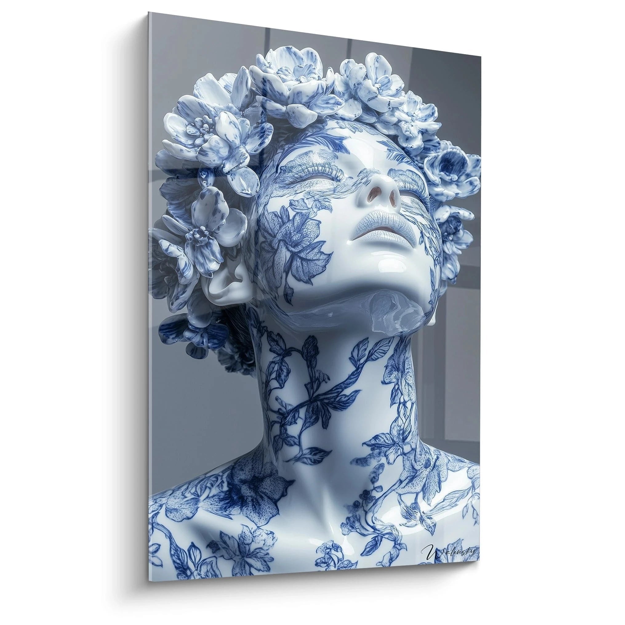 Un tableau porcelaine buste féminin orné de motifs bleu cobalt sur fond blanc éclatant, avec des fleurs sculptées en relief formant une couronne. Les détails botaniques s'étendent sur le visage et le cou avec une finition glacée caractéristique de la céramique fine.
