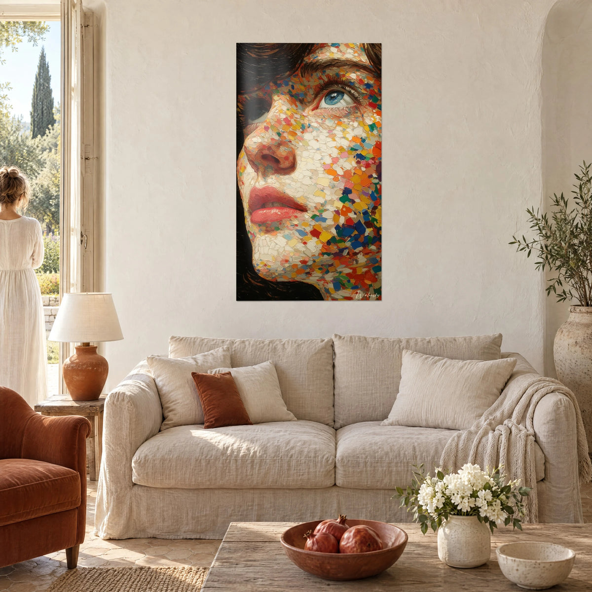 Wall art woman's face in a mosaic of ivory and orange pointillist dabs, blue eye gazing upward, above a sofa in a bright living room