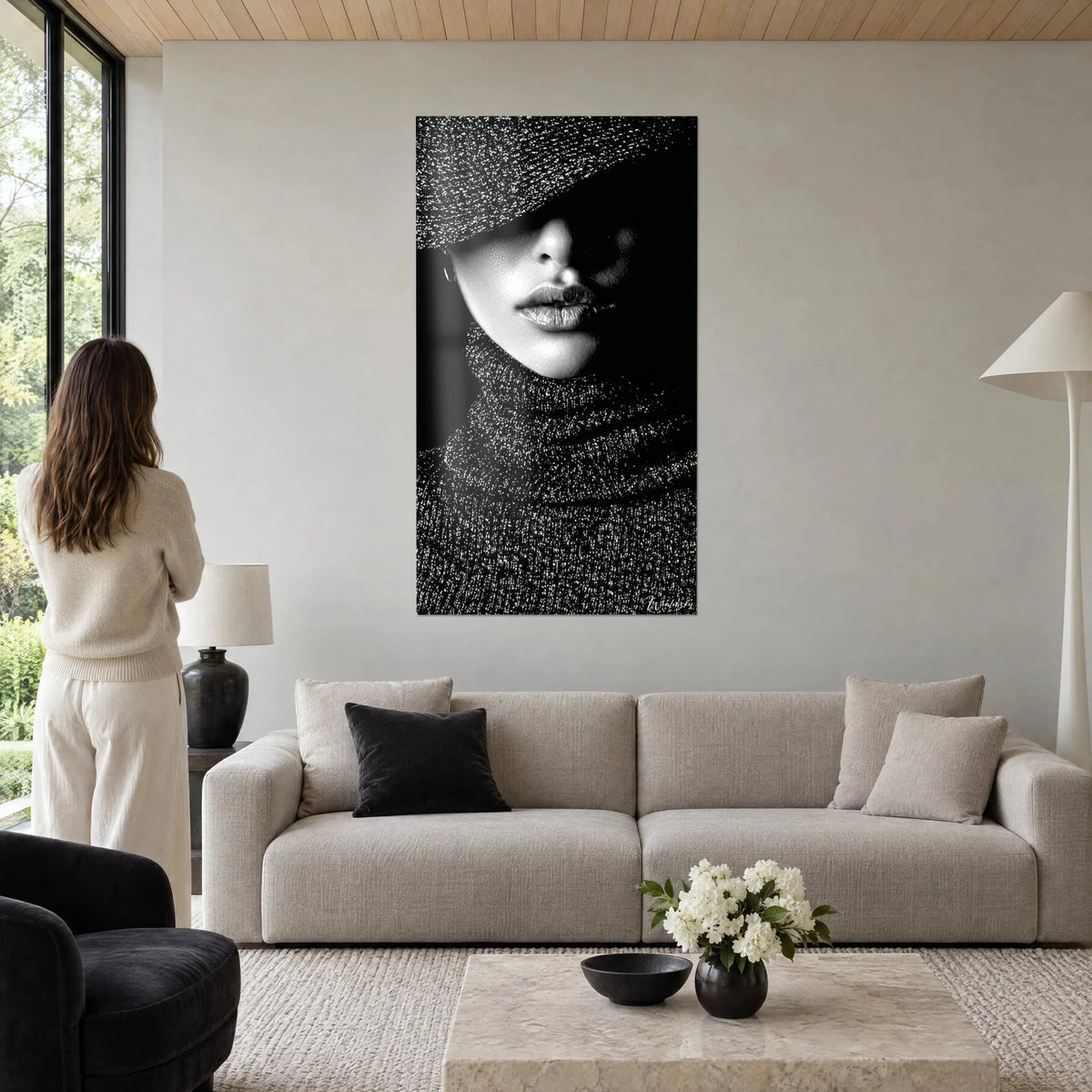 Tableau portrait mystérieux d'une femme au chapeau granuleux, lèvres argentées, noir et blanc, au-dessus d'un canapé dans un salon lumineux