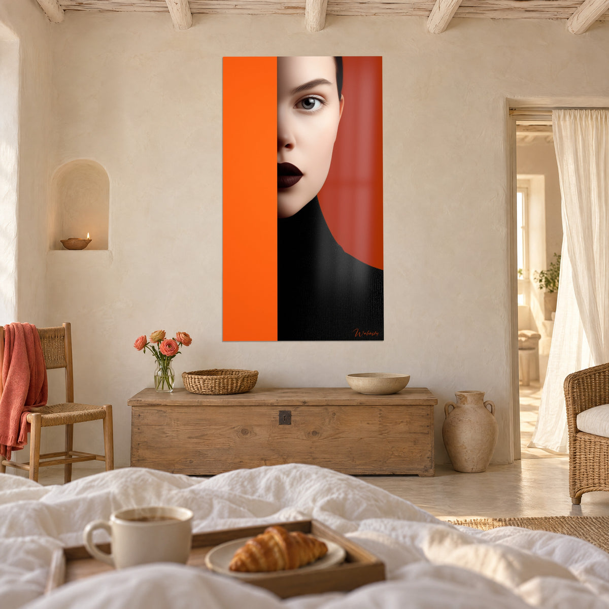Cuadro rostro de mujer cortado por una banda naranja, labios granate oscuro, cuello negro, sobre una cama en un dormitorio luminoso
