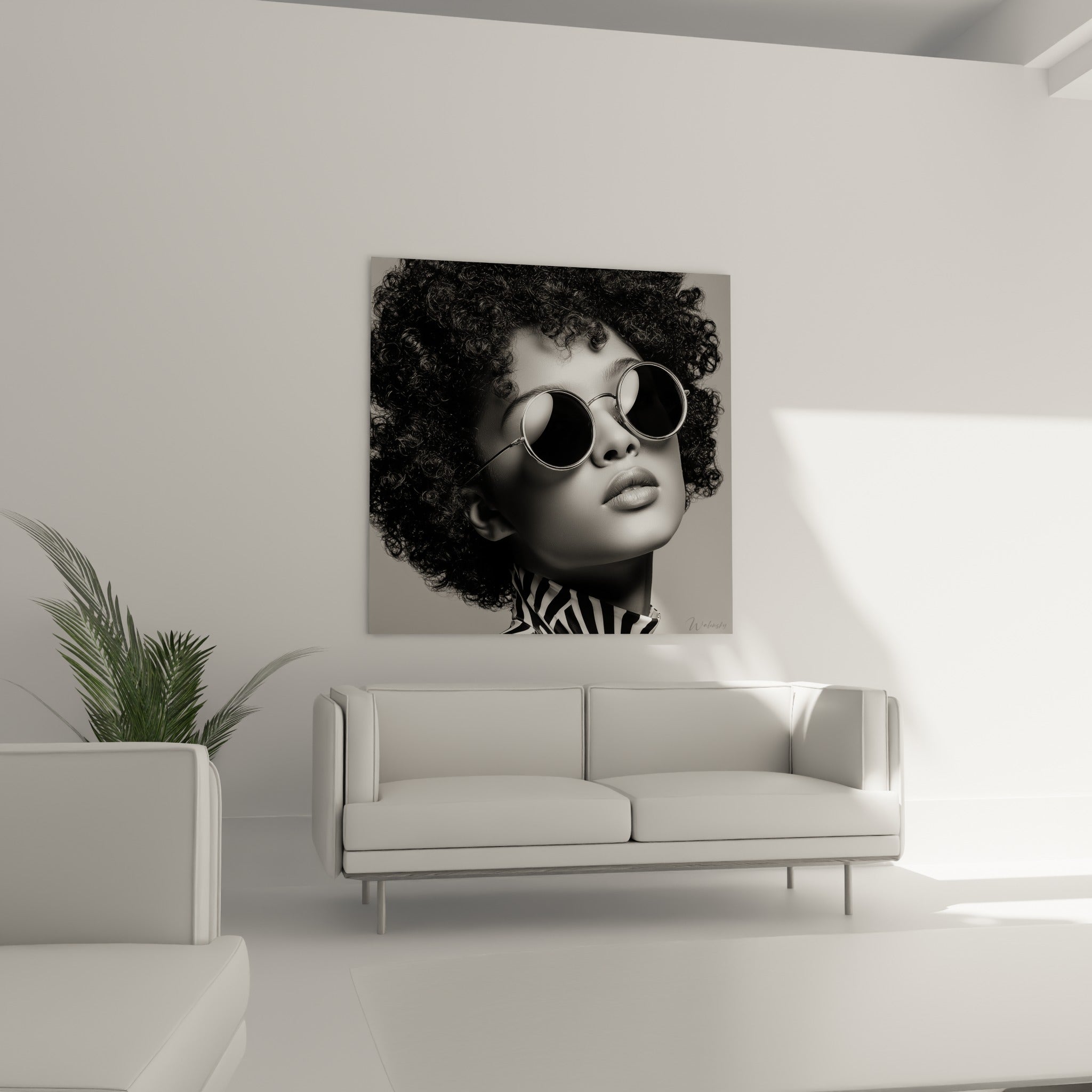 Chevelure afro dense noire et blanche, lunettes argentées, col rayé, au-dessus d'un canapé dans un salon lumineux