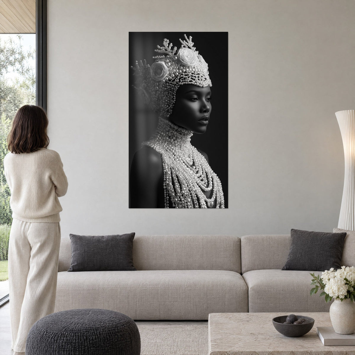 Tableau femme à la coiffe de perles nacrées, visage de profil en noir et blanc, dans un salon avec canapé gris, lumineux