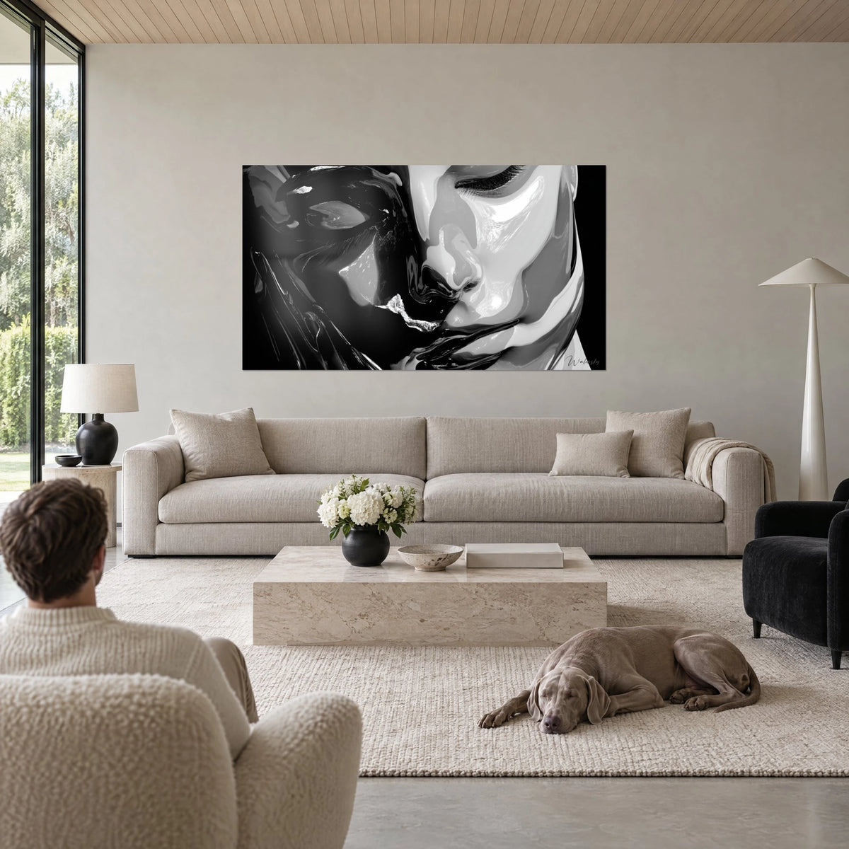 Wall art woman's face with closed eyelids, black and white lacquer blended together, above a sofa in a bright living room