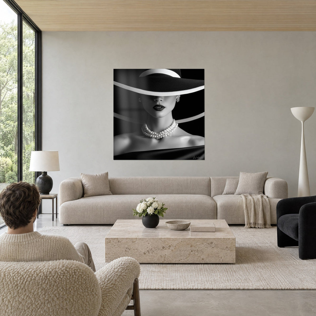 Tableau élégante au chapeau noir ourlé de blanc, lèvres sombres et perles nacrées, au-dessus d'un canapé dans un salon lumineux