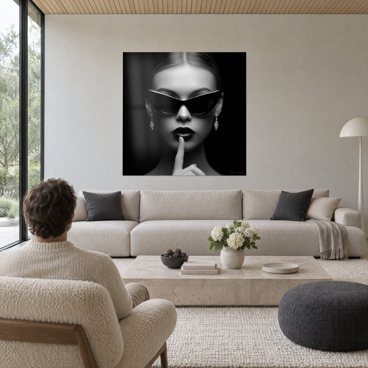 Tableau femme aux lunettes papillon noires, doigt sur des lèvres sombres, fond noir, au-dessus d'un canapé dans un salon lumineux