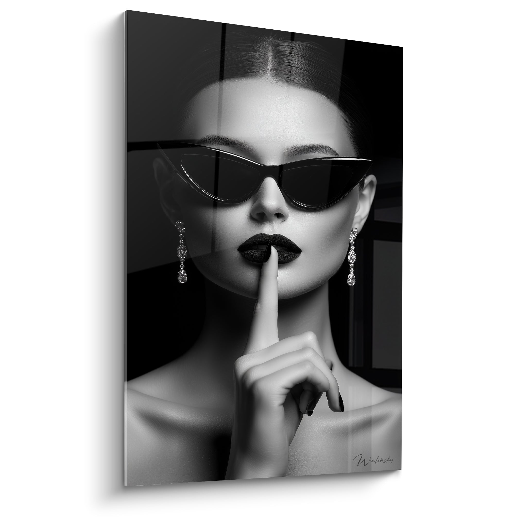 Visage noir et blanc d'une femme aux lunettes cat-eye, lèvres sombres, doigt sur la bouche