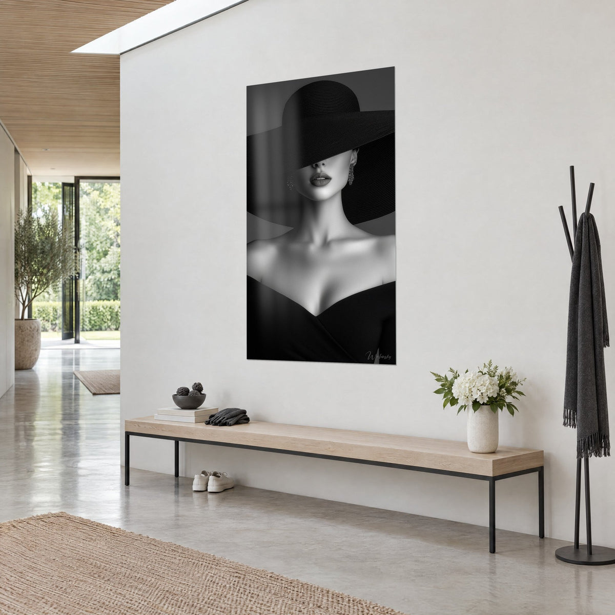 Quadro ritratto in bianco e nero, ampia tesa del cappello sugli occhi, orecchini pendenti, appeso in un ingresso luminoso