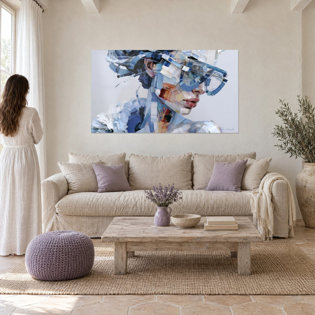 Tableau portrait fragmenté à lunettes translucides, bleu cobalt et blanc crème, vu par une femme de dos au-dessus d'un canapé dans un salon lumineux