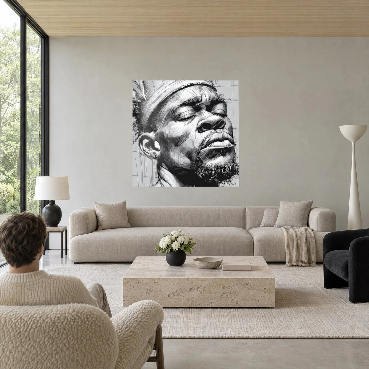 Cuadro retrato de hombre con los ojos cerrados, tinta negra y gris perla, turbante a rayas, encima de un sofá en un salón luminoso