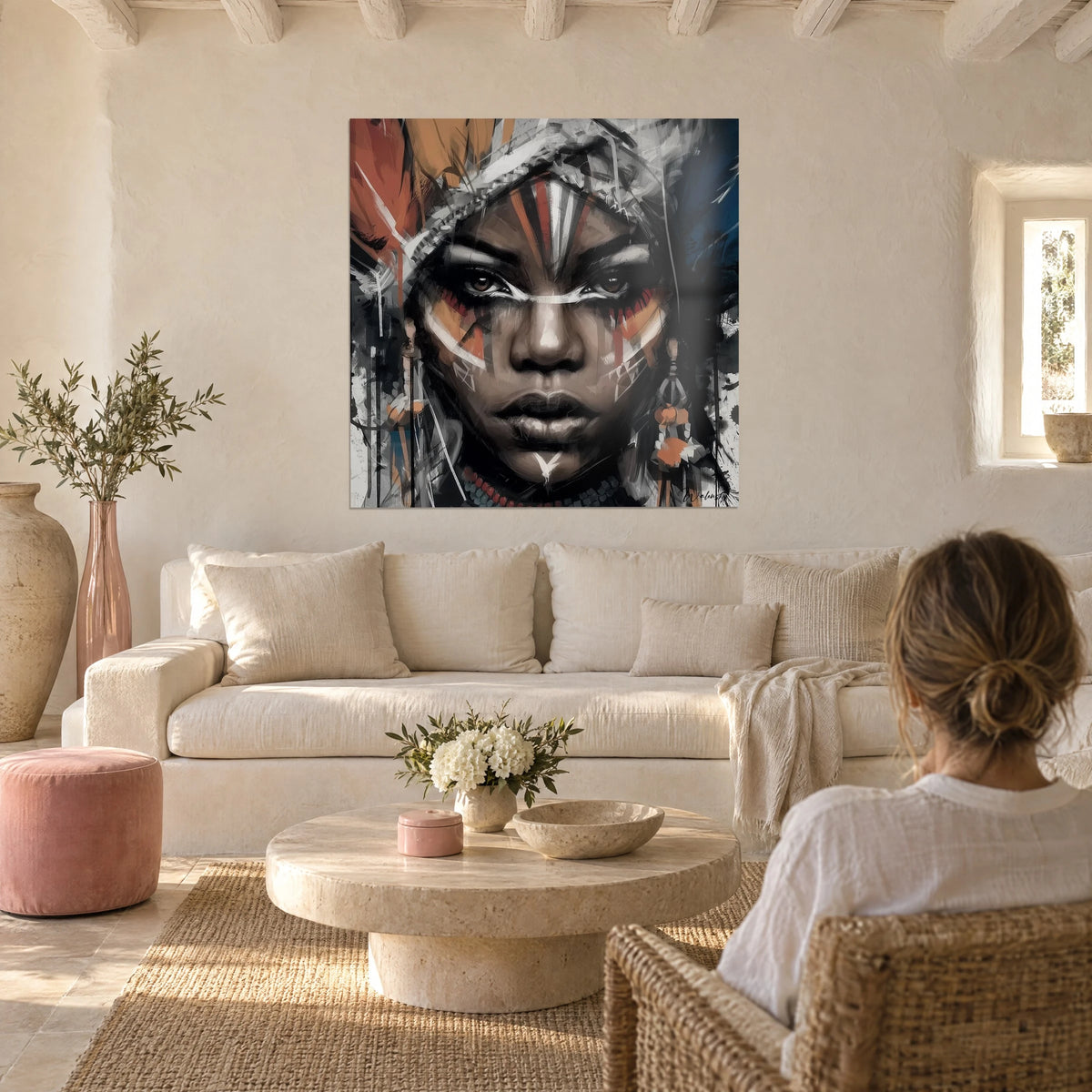 Tableau portrait guerrière aux yeux ambrés, plumes rouille et bleu nuit, traits blancs, au-dessus d'un canapé dans un salon lumineux