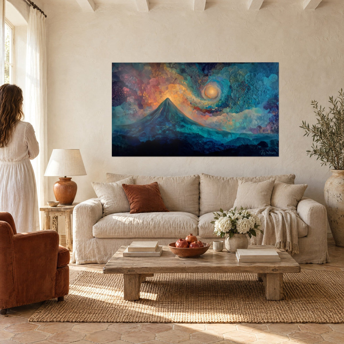 Tableau montagne conique bleu nuit sous un soleil spiralé orangé, accrochée au-dessus d'un canapé dans un salon lumineux