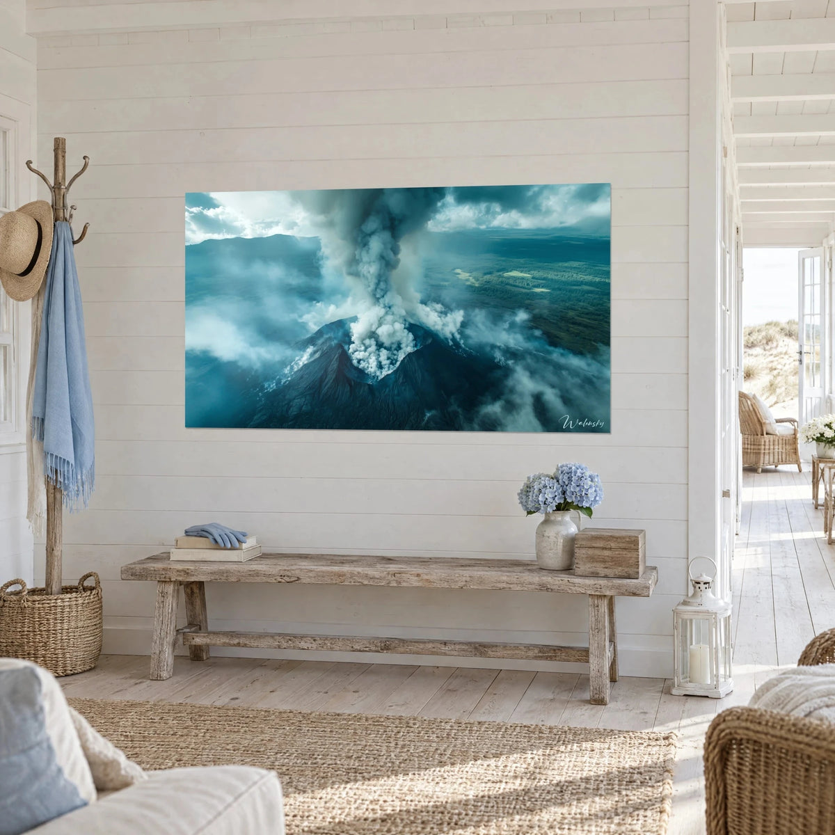 Wall art smoking crater seen from above, white and charcoal grey ash, green forest, in a seaside house entrance hall
