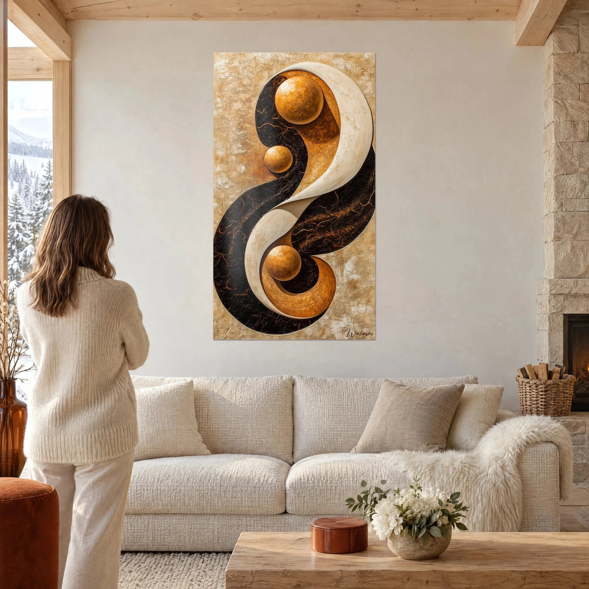 Quadro a spirale yin yang in crema e nero, tre sfere ramate, donna di spalle sopra un divano in un soggiorno luminoso