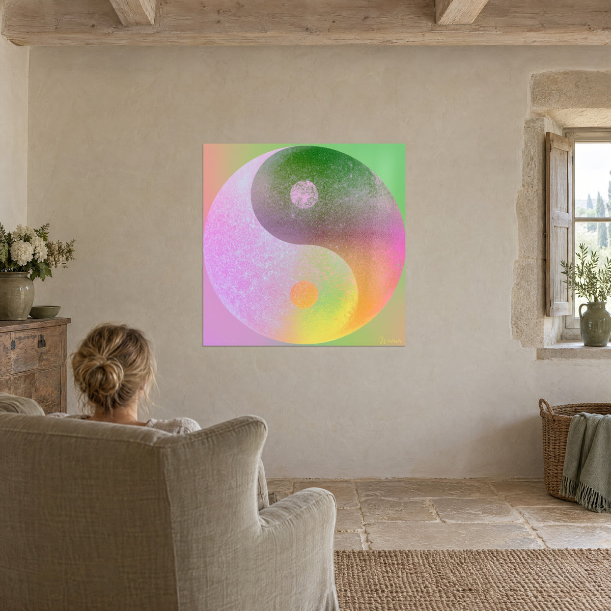 Tableau sphère rose et vert aux nuances jaune citron, point rose en haut, face à une personne assise dans un fauteuil en lin