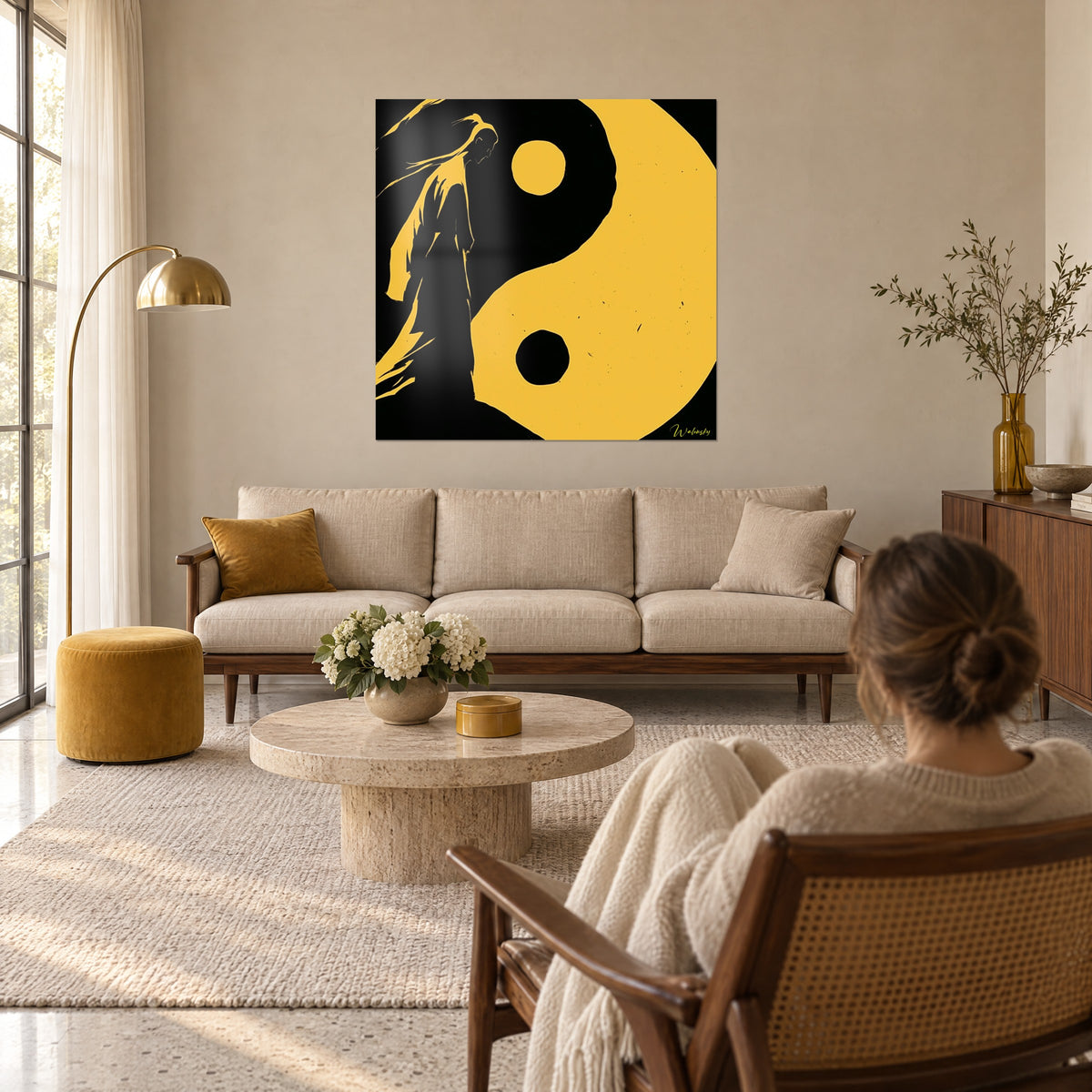Wall art ochre yin yang, black silhouette with long hair facing the yellow disc, above a sofa in a bright living room
