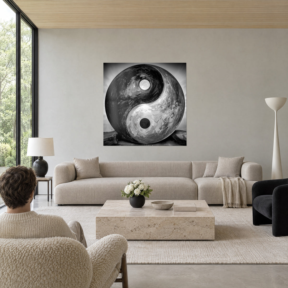 Tableau Yin Yang sphérique noir et blanc aux reflets argentés, deux points contrastés, au-dessus d'un canapé dans un salon lumineux