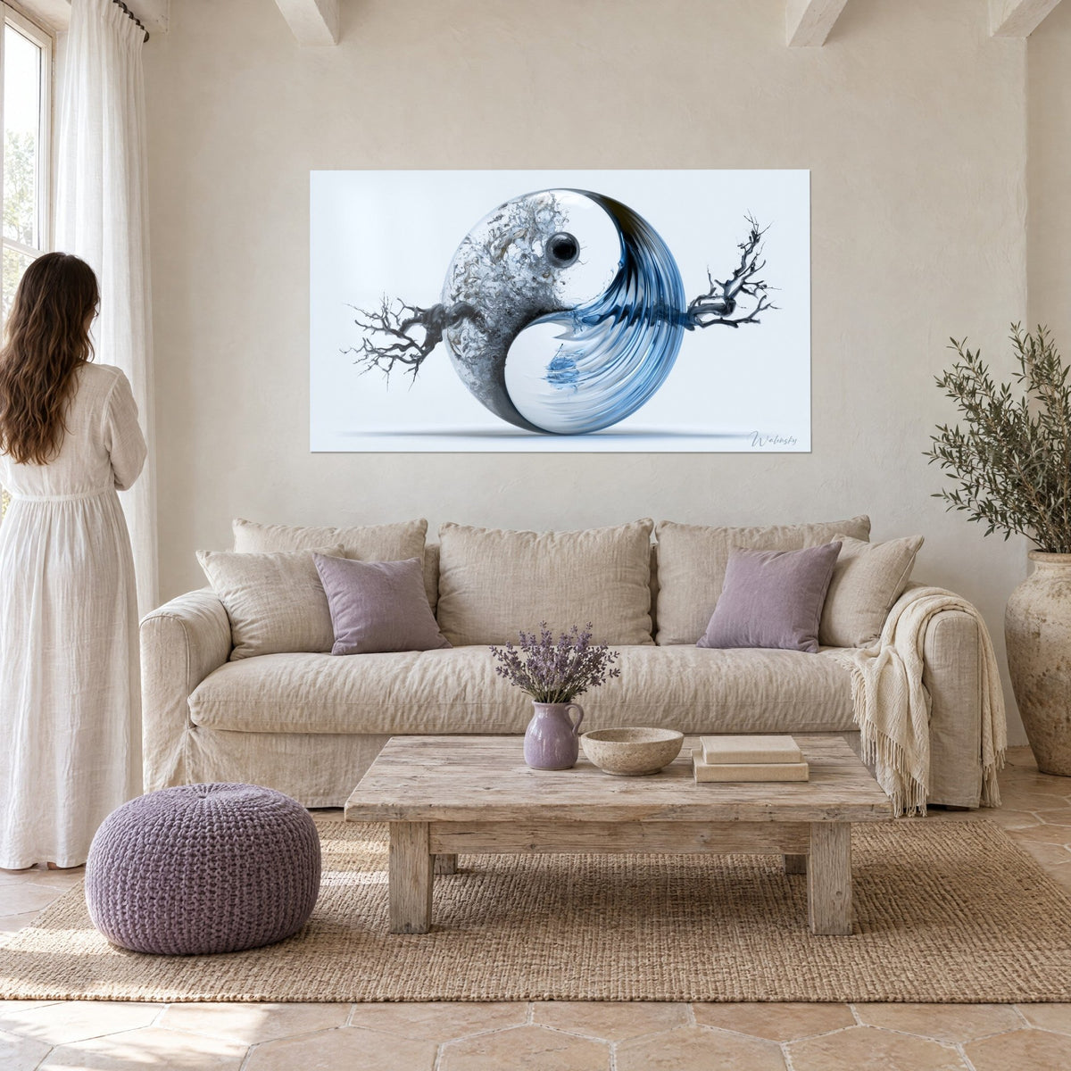 Tableau sphère yin yang de verre bleu et gris, branches noires aux bras tendus, au-dessus d'un canapé dans un salon lumineux