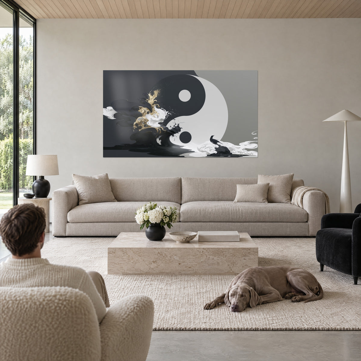 Tableau symbole yin yang noir et blanc, volutes d'encre et éclaboussures dorées, regardé par un couple de dos, au-dessus d'un canapé dans un salon lumineux