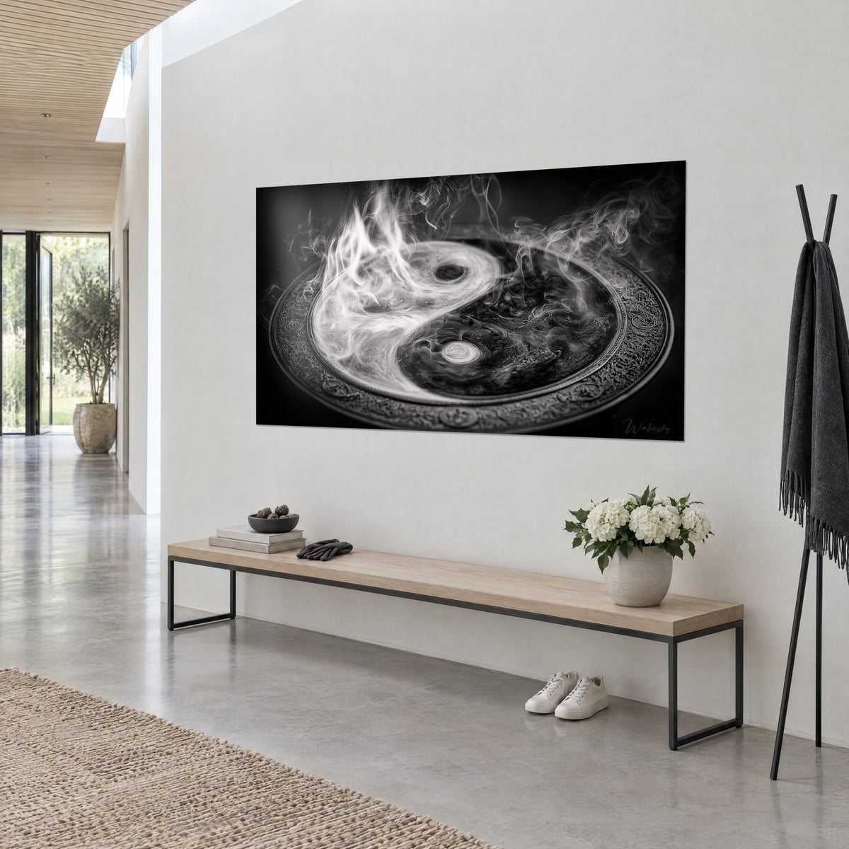 Wall art tao symbol with flaming swirls, mother-of-pearl white on black background, seen from three-quarters near a wooden and metal bench