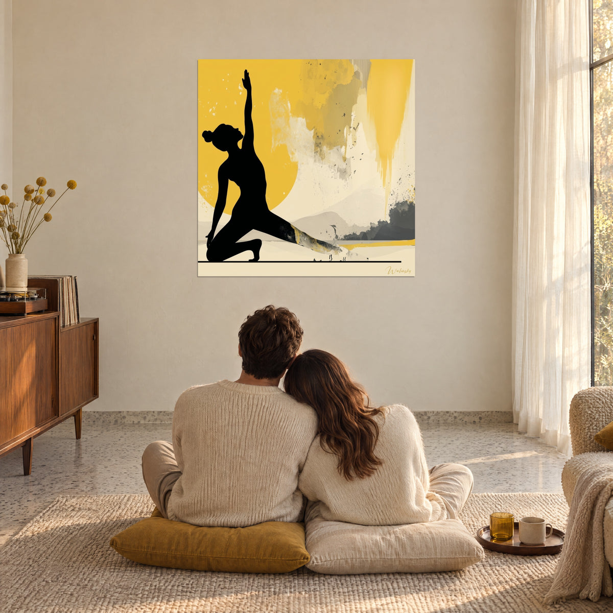 Quadro alba al sole, silhouette di ebano con le braccia verso il cielo, alone giallo oro e foschia avorio, osservato da una coppia seduta sui cuscini