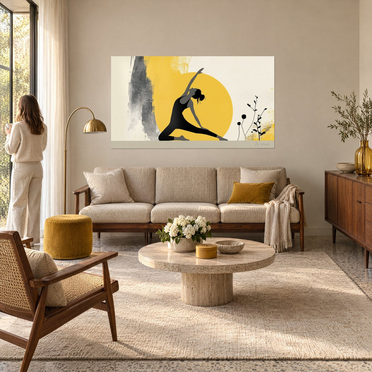 Wall art black stretched yoga pose silhouette in front of a mustard-yellow disc and grey strokes, above a sofa in a bright living room