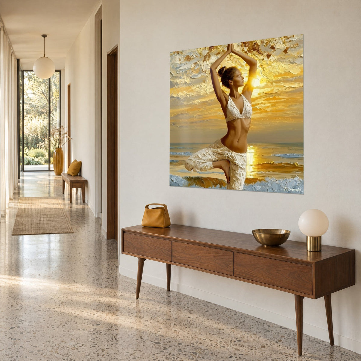 Wall art golden silhouette balancing at dusk, amber sky and blue-grey sea, three-quarter view down a hallway with a wooden sideboard