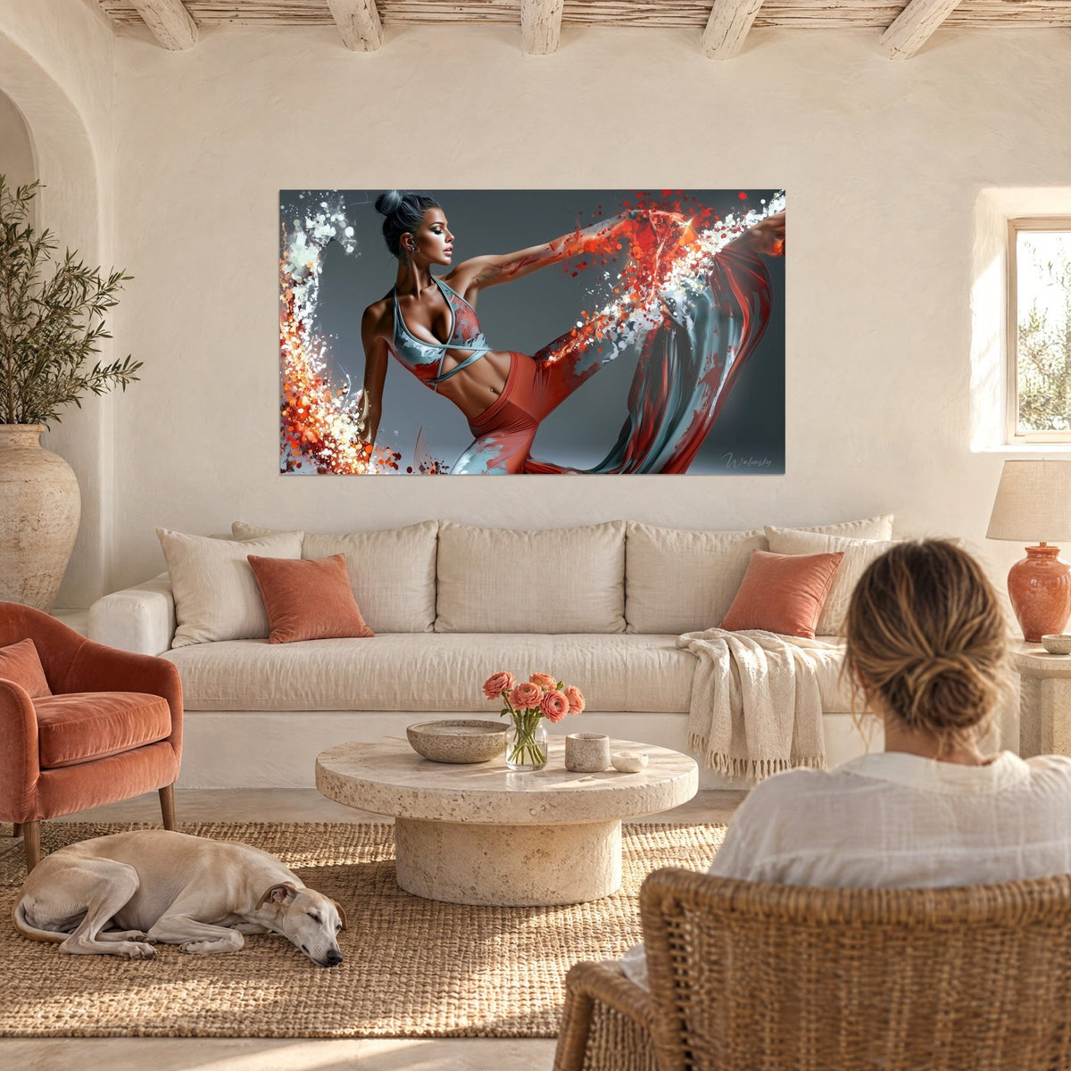 Wall art of a dancer in a split with a raised leg, terracotta and grey-blue fabric splashed around, hung above a sofa in a bright living room