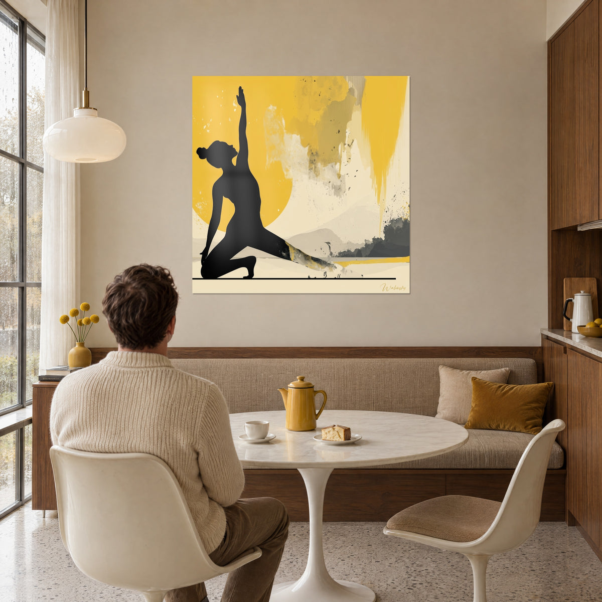 Quadro figura nera in affondo basso e sole ocra brillante, colature dorate e macchie grigie, di fronte a un uomo seduto in un angolo pranzo