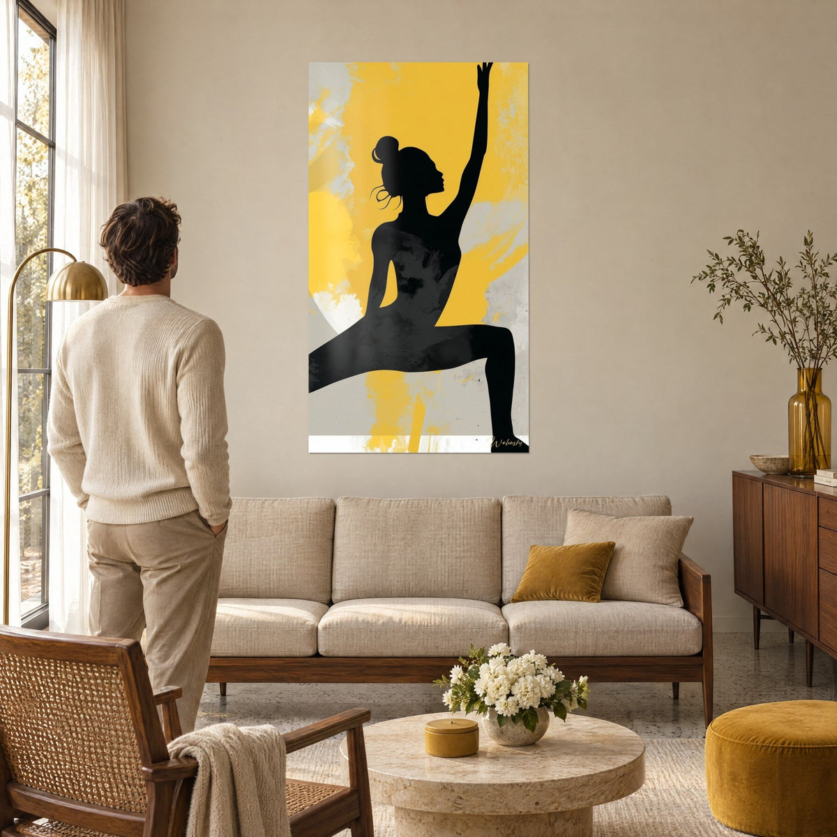 Wall art dancer in black shadow, arm stretched toward the sky, against a mustard yellow and grey background, above a sofa in a bright living room