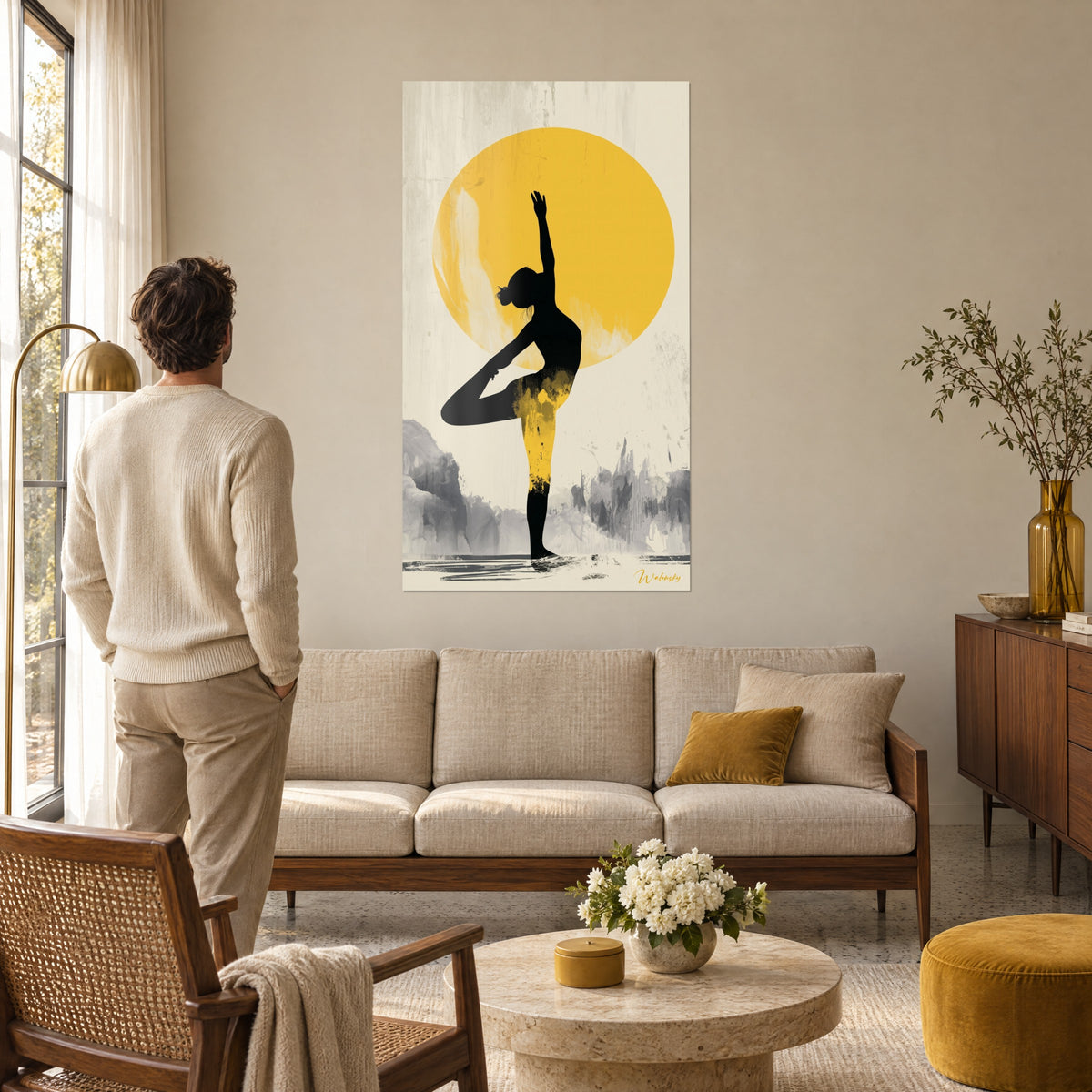 Quadro sagoma nera inarcata davanti a un disco giallo senape, sfondo crema e rocce grigie, uomo di spalle, sopra un divano in un soggiorno luminoso