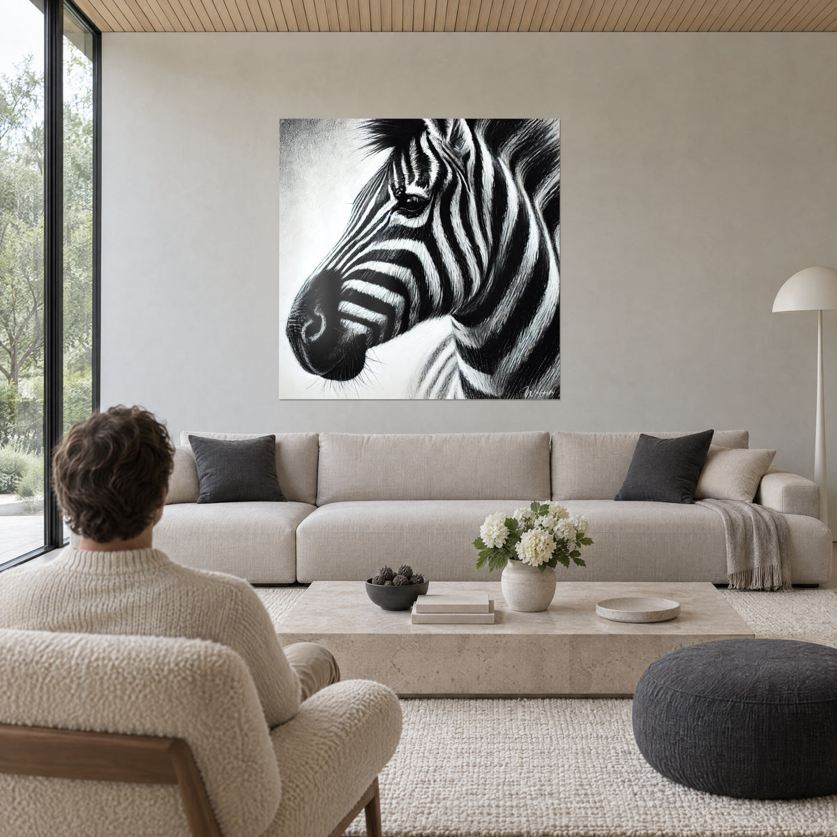 Obraz zebra o ciemnym spojrzeniu, czarno-białe pasy węglem, mężczyzna tyłem nad sofą w jasnym salonie