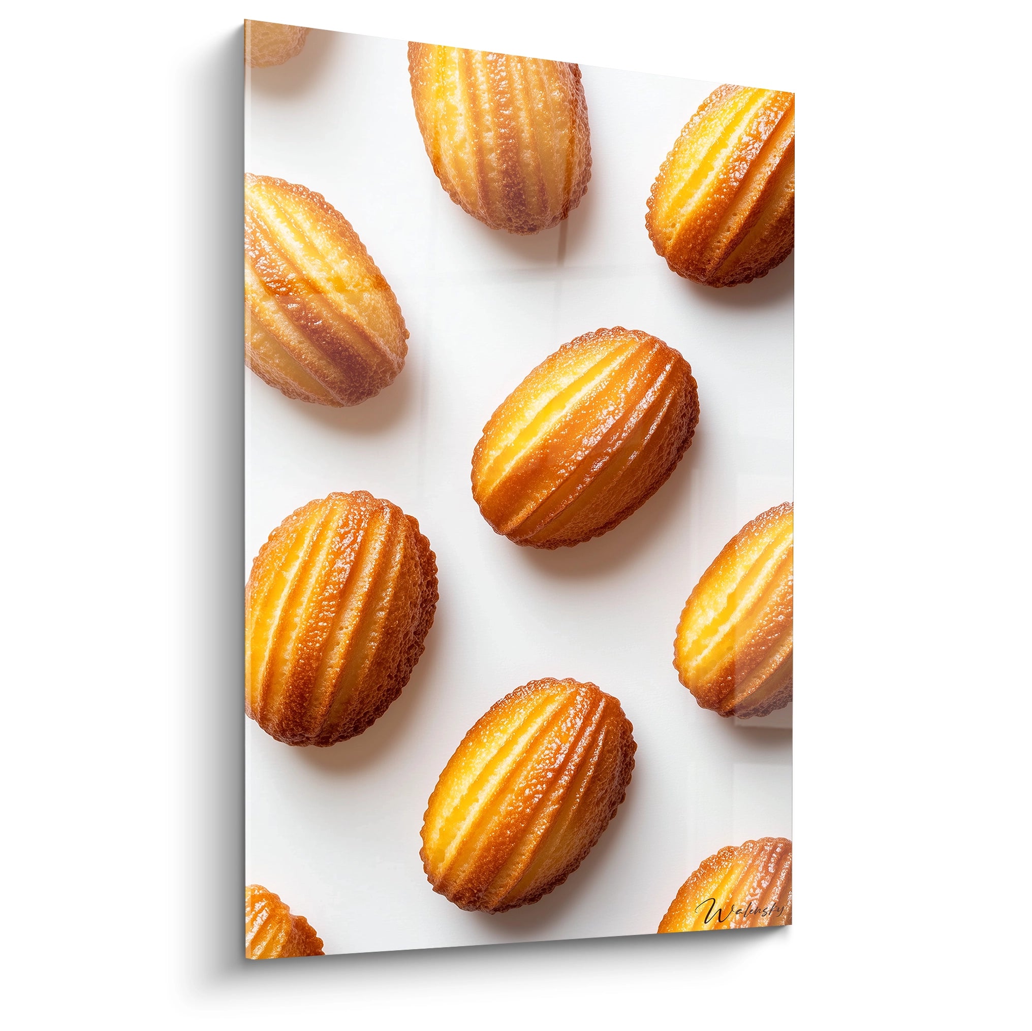 Un tableau madeleine présentant des pâtisseries ovales dorées sur fond blanc, avec des teintes jaune et orange, des textures lisses et une lumière accentuant les reliefs.

