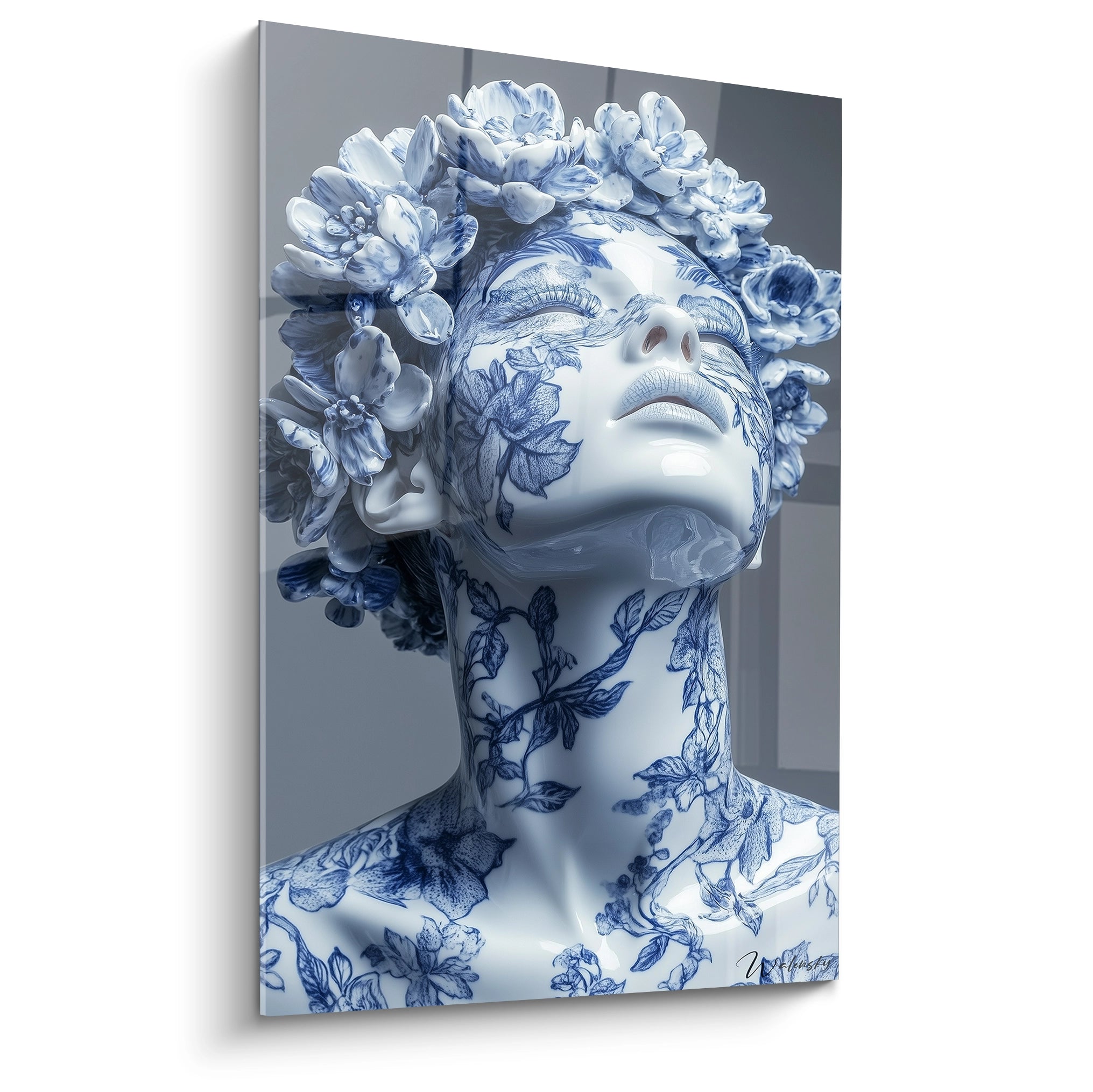 Un tableau porcelaine buste féminin orné de motifs bleu cobalt sur fond blanc éclatant, avec des fleurs sculptées en relief formant une couronne. Les détails botaniques s'étendent sur le visage et le cou avec une finition glacée caractéristique de la céramique fine.
