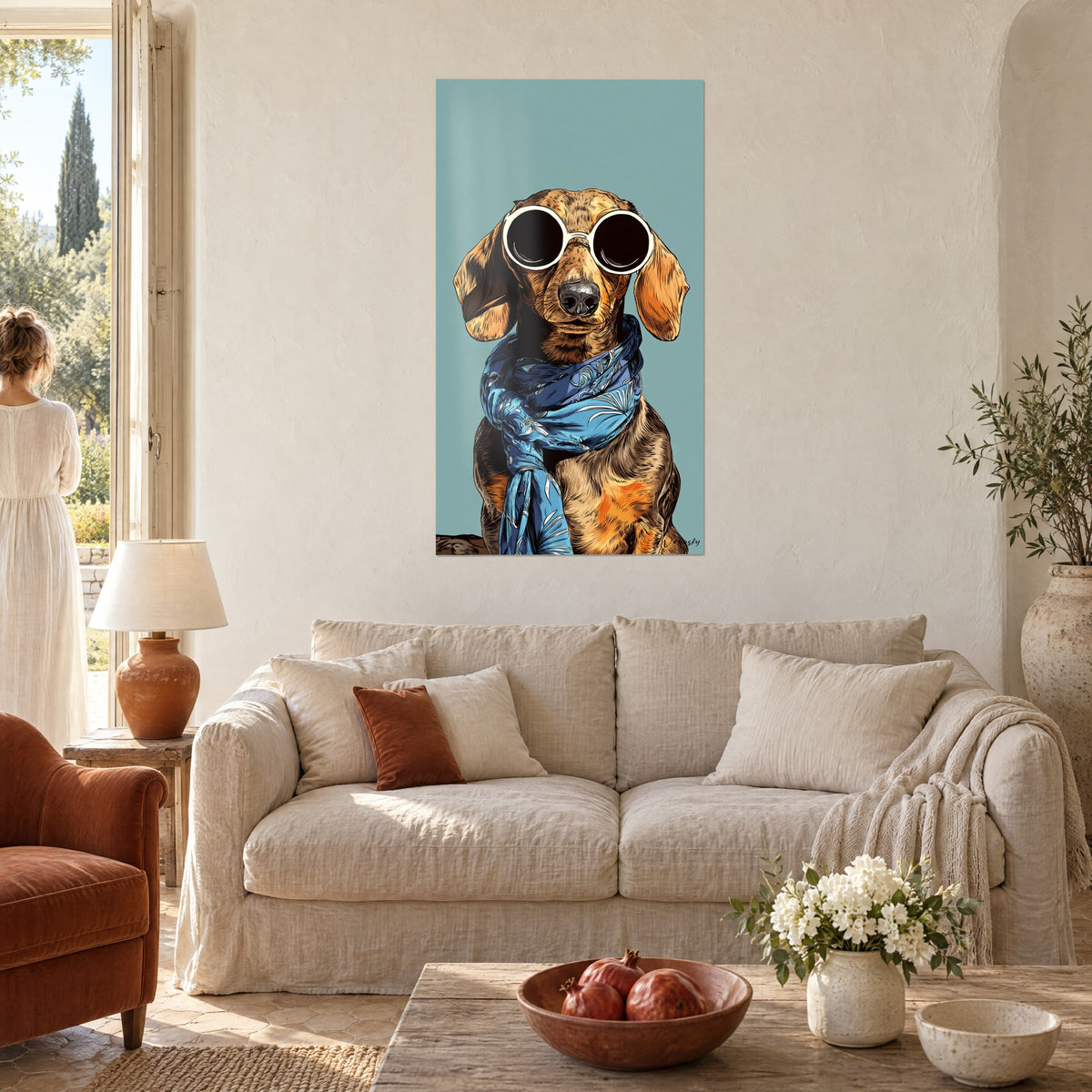 Cuadro perro salchicha con gafas redondas blancas y pañuelo azul, fondo turquesa, encima de un sofá en un salón luminoso