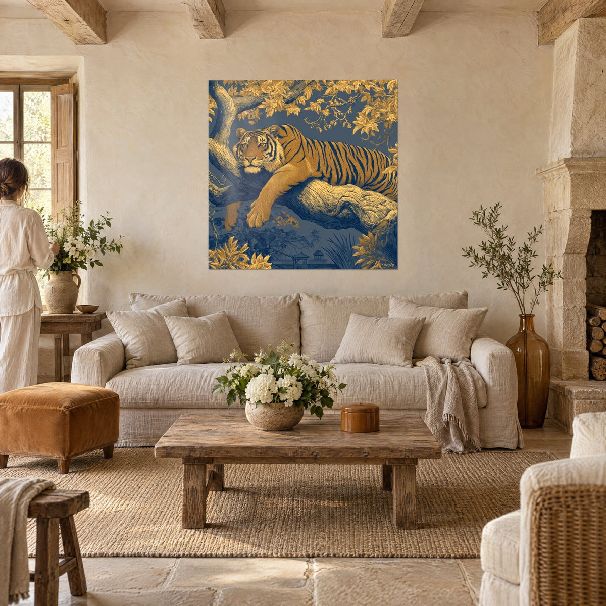 Quadro di una tigre dorata distesa su un ramo, strisce blu notte, fogliame ocra, visto da due persone sopra un divano in un soggiorno luminoso