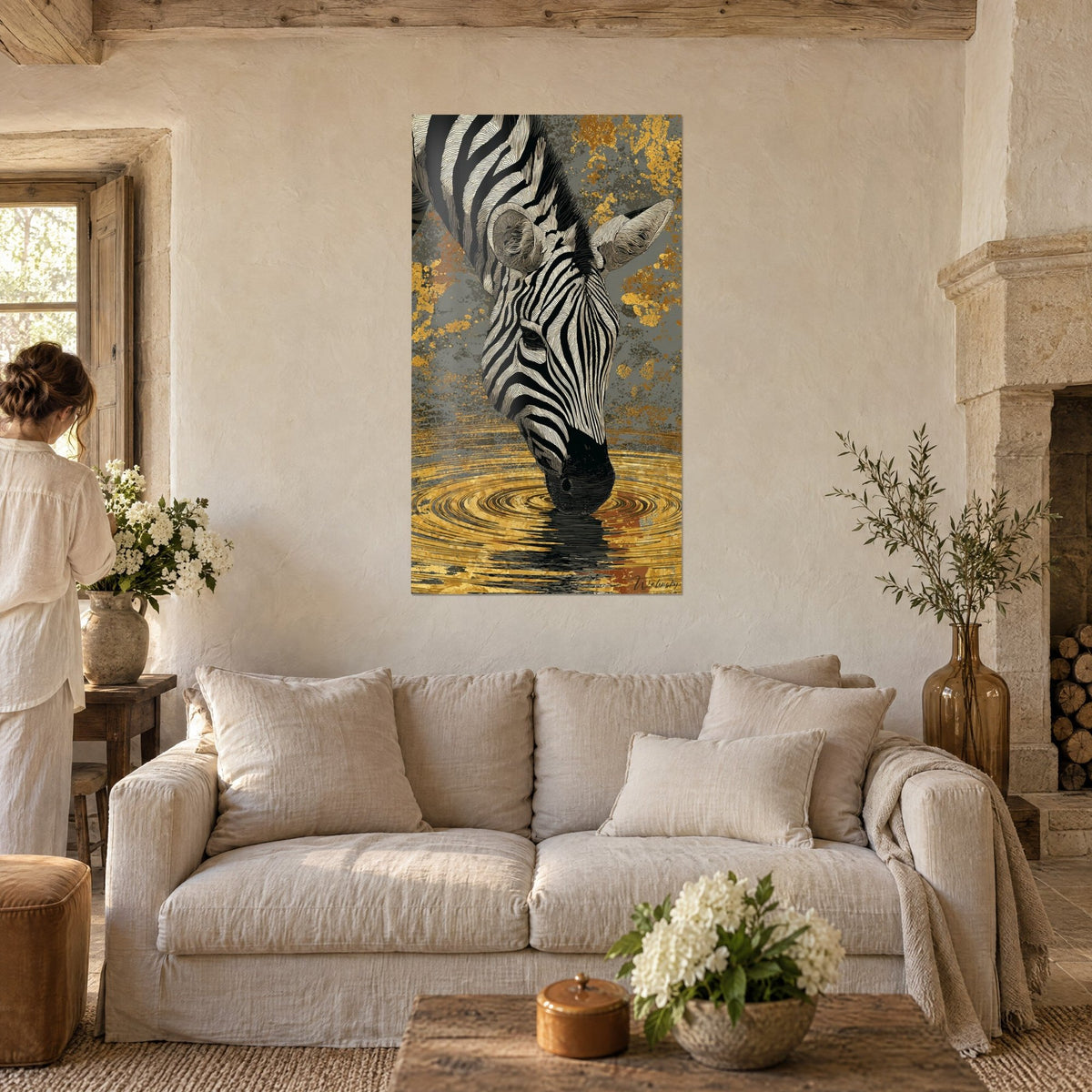 Gemälde Zebra beim Trinken aus goldschimmerndem Wasser, schwarze und cremefarbene Streifen, Goldflecken auf grauem Grund, über einem Sofa in einem hellen Wohnzimmer