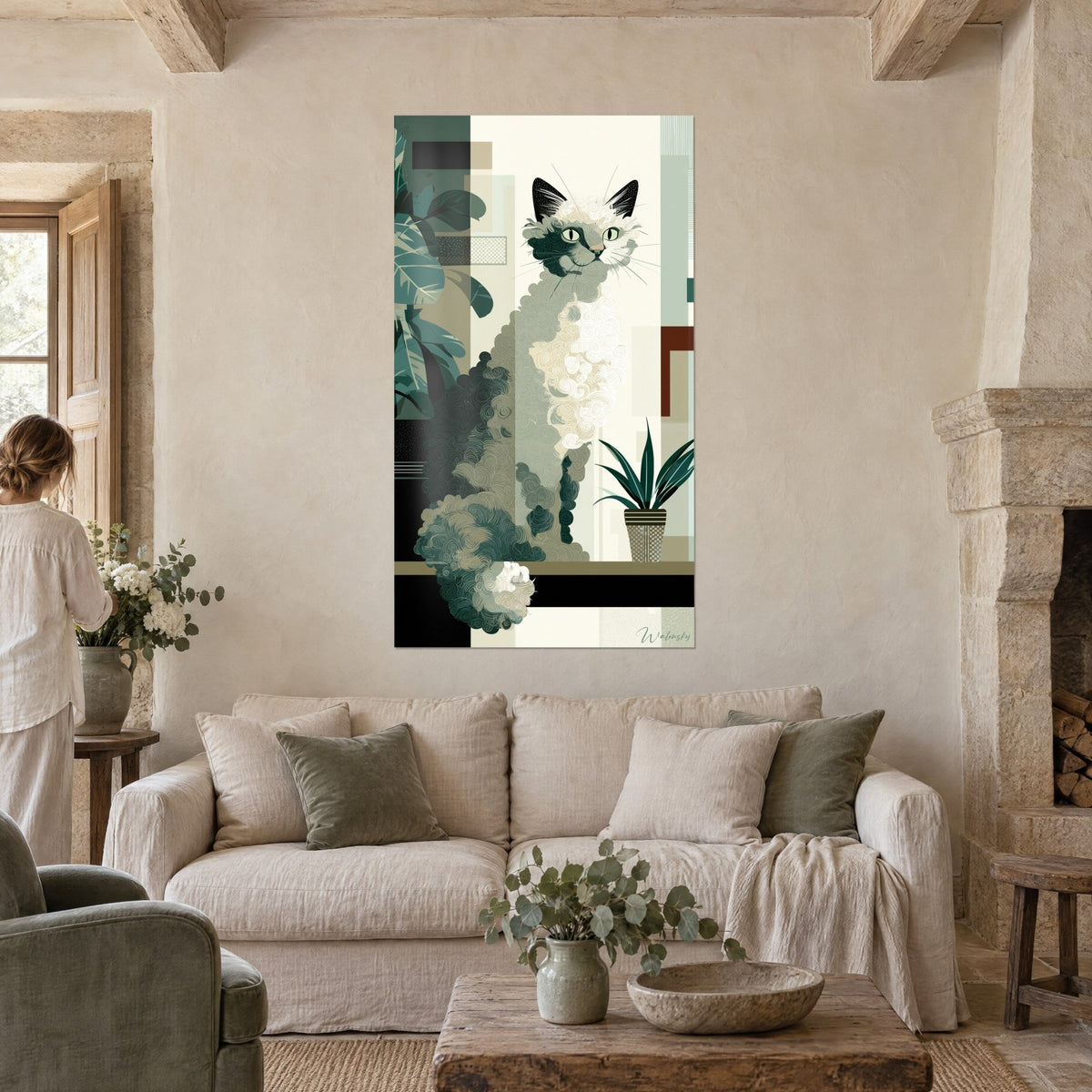 Tableau chat bouclé crème et noir aux yeux verts, feuillage vert sapin, au-dessus d'un canapé dans un salon lumineux
