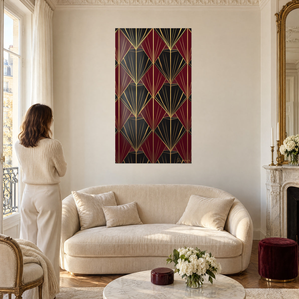 Tableau motif art déco en éventails bordeaux et noirs, filets dorés, une femme de dos, au-dessus d'un canapé dans un salon lumineux