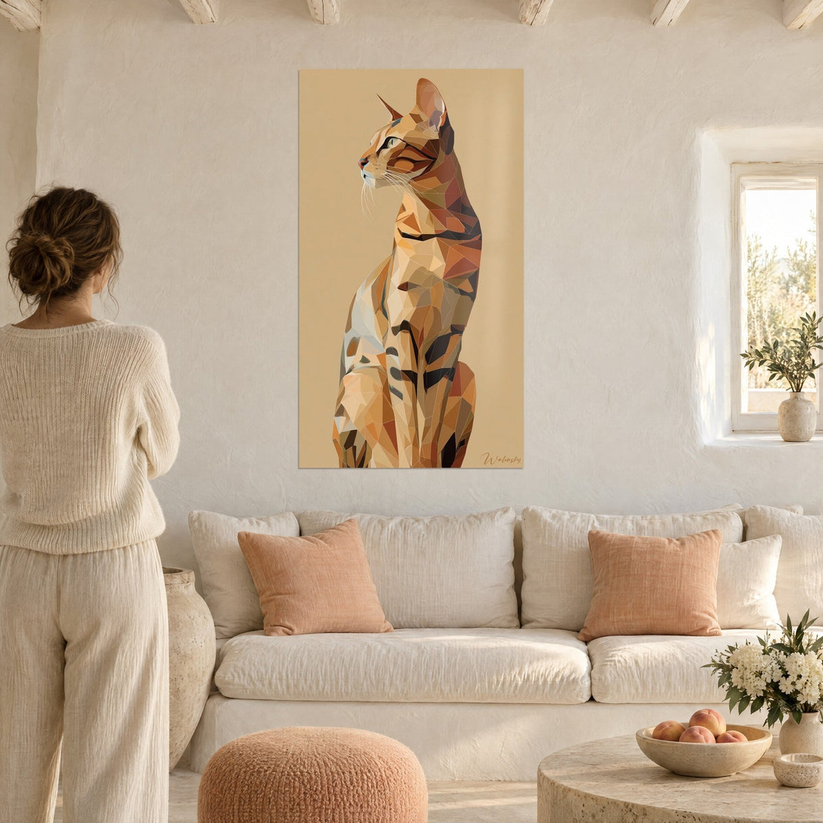 Gemälde Serengeti-Katze im Profil aus ockerfarbenen und rotbraunen Facetten, sandfarbener Hintergrund, Frau von hinten, über einem Sofa in einem hellen Wohnzimmer